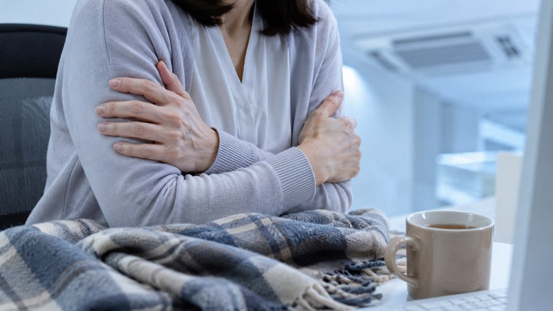 冷房の効いた室内で冷えとだるさを感じる女性(福岡のレイキヒーリングで整えたい不調)